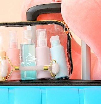 A toiletry case packed with skincare bottles.